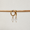 Goldene Creolen aus hypoallergenem Edelstahl mit herzförmigen Bergkristalle-Anhängern – handgemachter Schmuck von Miwi Jewels.