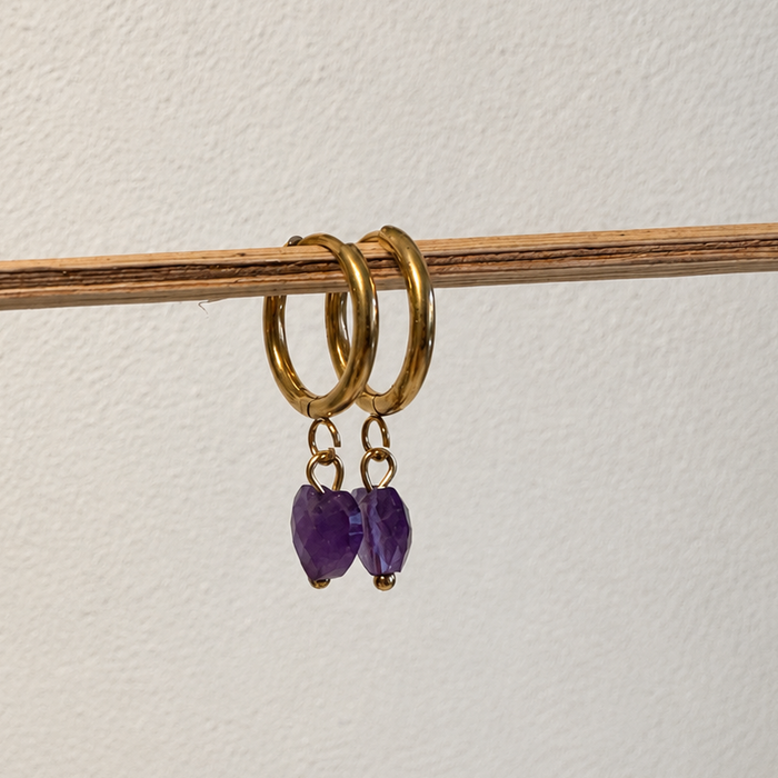 Goldene Creolen aus hypoallergenem Edelstahl mit herzförmigen Amethyst-Anhängern – handgemachter Schmuck von Miwi Jewels.